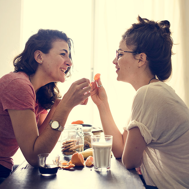 same sex couple living together having snack